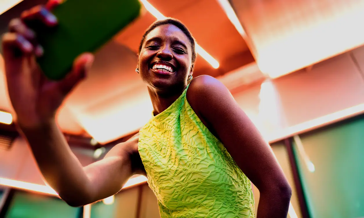 Creator filmed from three-quarter angle with bold, electric neon color grading
