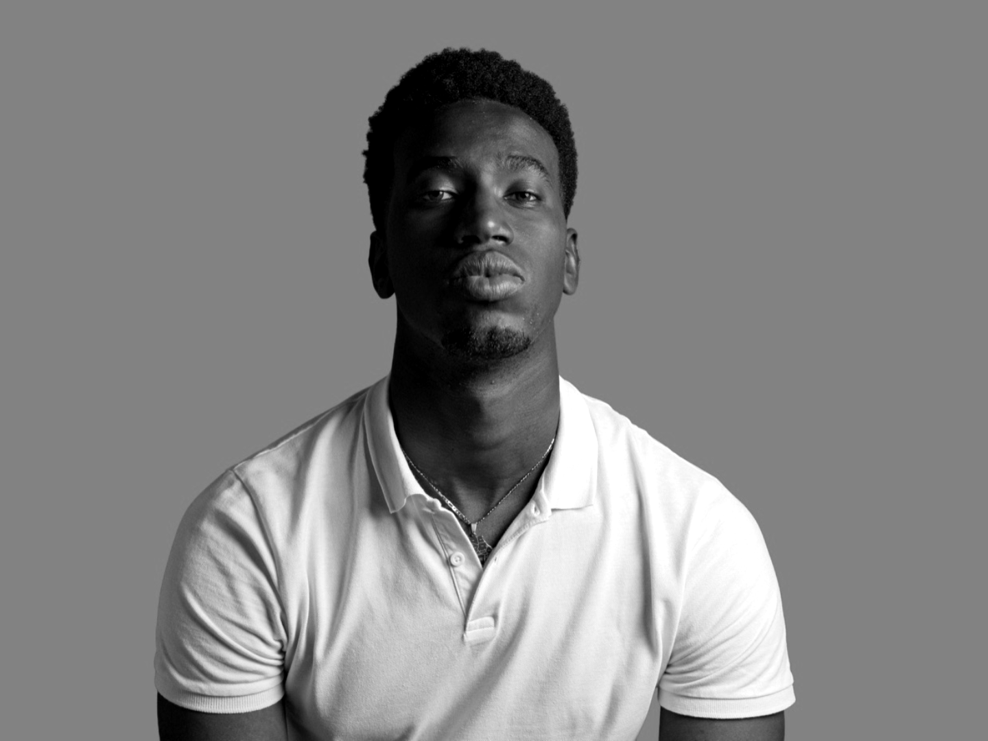 A person in front of a green-screen backdrop in monochrome